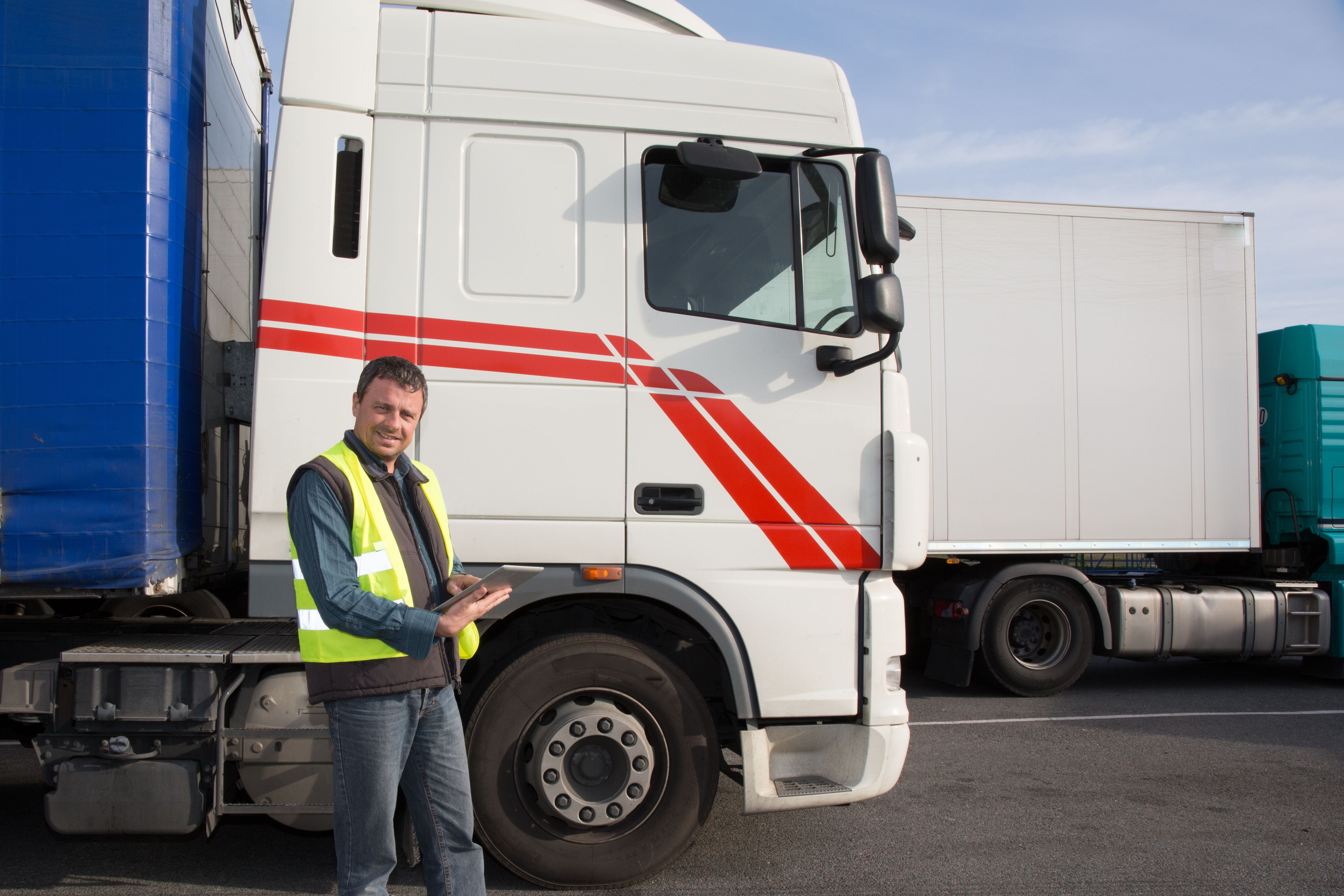 truck driver outside vehicle with ipad