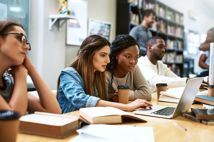 Female College Students Working in Library