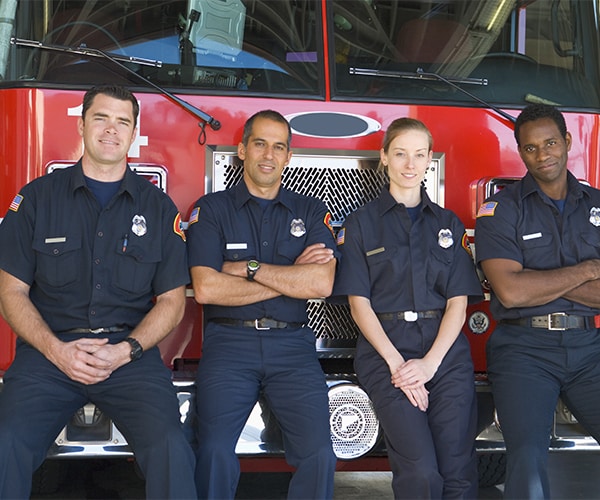 Firefighters standing in front of a fire truck