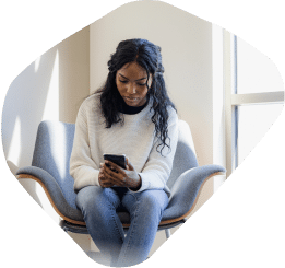 Woman sitting on a chair looking at her phone